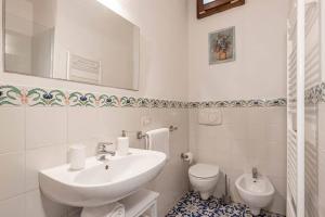 Un baño blanco con lavabo e inodoro. en Poggio Imperiale House(Porta Romana), en Florencia 13 fotos más