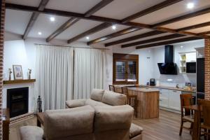 a living room with a couch and a kitchen at Casa Rural La Madroña in Fuentelabrada de los Montes