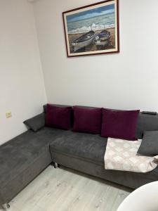 a couch in a living room with a picture on the wall at Apartments Oliva in Poreč