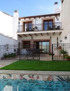 a house with a balcony and a yard at Casa Rural La Madroña in Fuentelabrada de los Montes