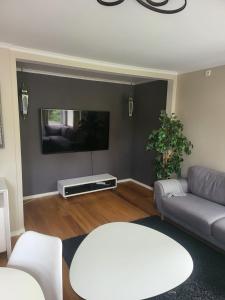 a living room with a couch and a tv at Nesttunveien appartments in Bergen