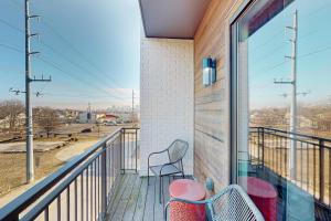 balcón con 2 sillas y ventana grande en Stay Awhile in Music City #302, en Nashville