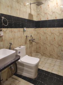 a bathroom with a white toilet and a sink at Hotel Luxury Holiday - Banjara hills prime location in Hyderabad