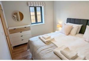 a bedroom with a large white bed with towels on it at Meadow View Lodges in Bury Saint Edmunds