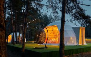 a large dome tent on a green table with trees at Daxvalley Glamping in Tsalka