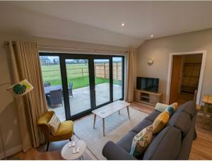 a living room with a couch and a television at Meadow View Lodges in Bury Saint Edmunds