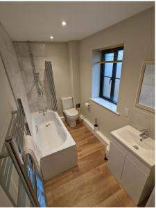 a bathroom with a tub and a toilet and a sink at Meadow View Lodges in Bury Saint Edmunds