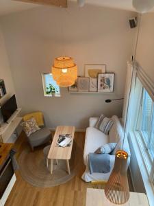 uma sala de estar com um sofá e uma mesa em Tiny grey house with loft, 15 min from city center em Gotemburgo