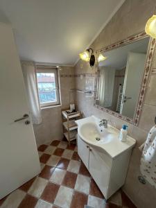 a bathroom with a sink and a mirror at Apartments Oliva in Poreč
