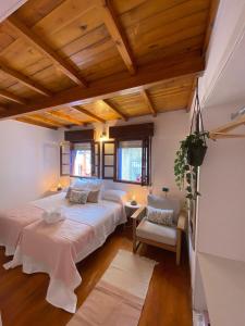 two beds in a room with wooden ceilings at Casa en Cudillero casco antiguo in Cudillero