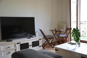a living room with a flat screen tv on a cabinet at HOCORAS Apartment in Geneva