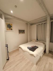ein Schlafzimmer mit einem weißen Bett in einem Zimmer in der Unterkunft Appartement LA BOURSE in Brüssel