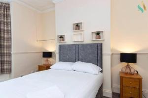 1 dormitorio con 1 cama blanca y 2 lámparas en Holt house, en Hartlepool