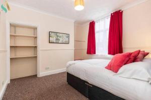 1 dormitorio con 1 cama con cortinas rojas y ventana en Holt house, en Hartlepool