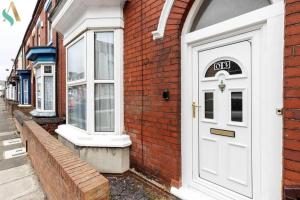 a white door on the side of a brick building at Holt house in Hartlepool