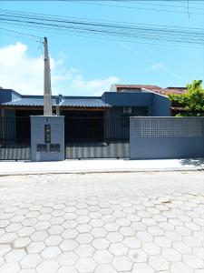 a building with a fence in front of a street at Casa praia in Itajubá