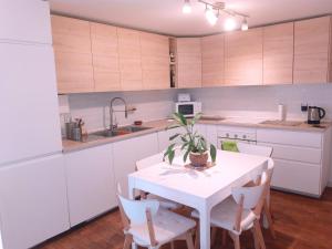 cocina con mesa blanca y armarios blancos en Habitaciones en Centro Histórico Alameda, en Sevilla