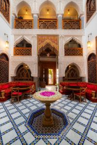 a large room with a table in the middle of a building at Riad Mazar in Fez
