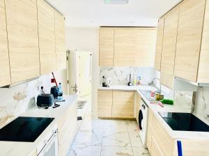 a kitchen with white counters and wooden cabinets at FOSSE LUXURY ROOMS in Leicester