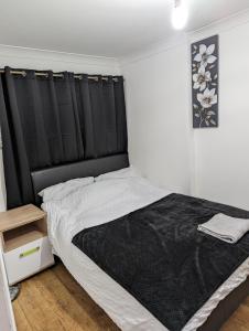 Luxury flat في Nevendon: غرفة نوم مع سرير كبير مع اللوح الأمامي الأسود