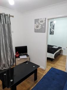 a living room with a table and a bed at Luxury flat in Nevendon