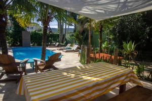 un patio con mesa y sillas y una piscina en Pousada Vila Mariscalia, en Bombinhas