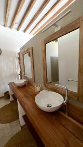a bathroom with two sinks and two mirrors at Boutique Villa Unaweza in Matemwe