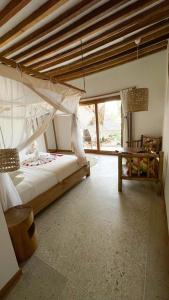 a bedroom with a large bed and a window at Boutique Villa Unaweza in Matemwe