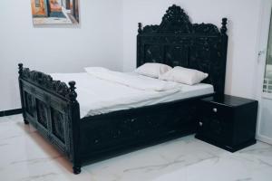 a black bed with white sheets and pillows on it at Ayaa Luxury Apartment 4th Floor Zanzibar in Zanzibar City