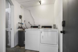 a laundry room with a refrigerator and a microwave at Capri 107 in Marco Island