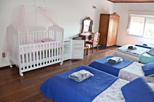 a nursery with three beds and a baby crib at Hotel rios rua uruguai n 99 in Jaguarão