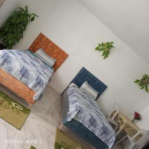 Zimmer mit 2 Betten und Kissen auf dem Boden in der Unterkunft Dar ettawfik in Tataouine