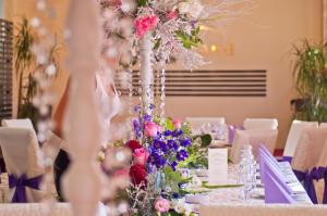 a table with a centerpiece of flowers and candles at Hotel Premier Botosani in Botoşani