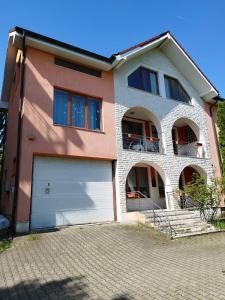uma casa grande com garagem numa entrada de tijolos em Casa cu Flori em Cluj-Napoca