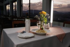 una mesa con un plato de comida y una botella de vino en Hotel Qhawarina de Casas Kolping Bolivia S.R.L., en Sucre
