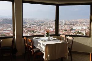 a table in a restaurant with a view of a city at Hotel Qhawarina de Casas Kolping Bolivia S.R.L. in Sucre