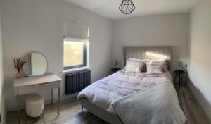 a bedroom with a bed and a desk and a mirror at Seabreeze Cottage in Portstewart