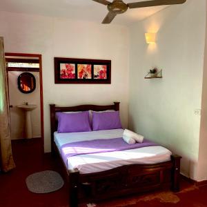 a bed in a room with purple pillows at Minca Santa Marta Casa Scalea in Minca