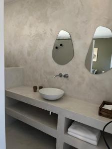 ein Bad mit einem Waschbecken und einem Spiegel in der Unterkunft Gîte de charme Uzès de 10 à 24 personnes in La Bastide-dʼEngras