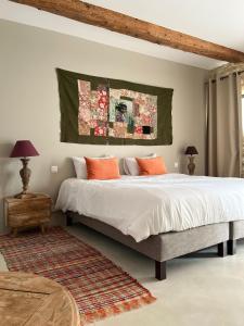 1 dormitorio con 1 cama grande con almohadas de color naranja en Gîte de charme Uzès de 10 à 24 personnes, en La Bastide-dʼEngras