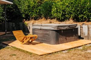 a wooden deck with a chair and a hot tub at Ferienhaus Lacher in Baiersbronn