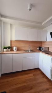 a kitchen with white cabinets and a sink at Słoneczny apartament w centrum Gdyni in Gdynia