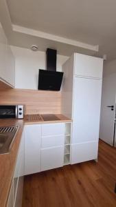 a kitchen with white cabinets and a white refrigerator at Słoneczny apartament w centrum Gdyni in Gdynia