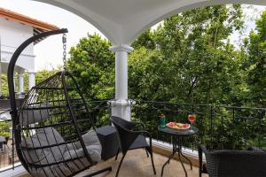 - une balançoire sur une terrasse couverte avec une table et des chaises dans l'établissement Shana by the Beach Manuel Antonio, à Manuel Antonio