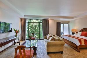 a large bedroom with a bed and a couch at Shana by the Beach Manuel Antonio in Manuel Antonio