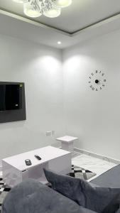 a white room with a table and a clock on the wall at Blueocean.cog in Benin City