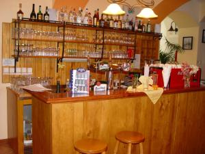 een bar met krukken en glazen aan de muur bij Hotel Galerie in Třeboň