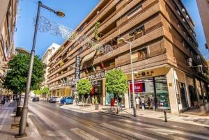 uma rua da cidade com um edifício ao lado da estrada em APARTAMENTO EN CALLE RECOGIDAS em Granada