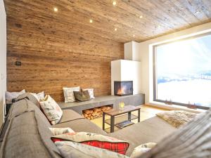 a living room with a couch and a large window at The Mountain Hideaway 211 by AA Holiday Homes SKI IN SKI Out Die Tauplitz in Tauplitz