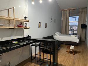 ein Zimmer mit einer Küche und ein Schlafzimmer mit einem Bett in der Unterkunft Skyloft Chalé in Governador Valadares